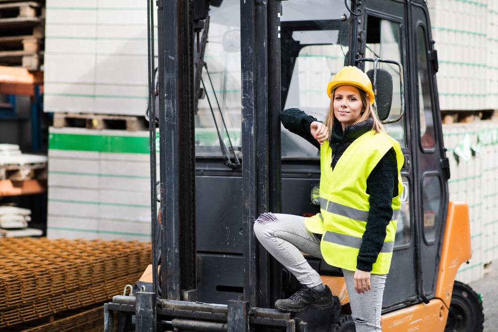 Vrouw met forklift in opslag aan het werk